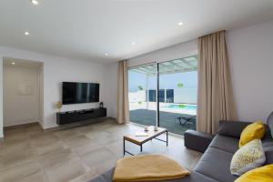 Una sala de estar con un sofá y un televisor. en Villa Gara 8, en Puerto Calero