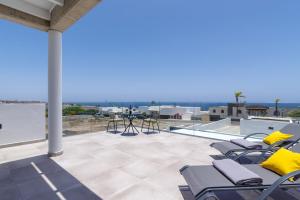 Un patio con sillas y vista al mar. en Villa Gara 8, en Puerto Calero
