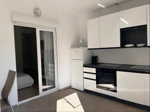 a kitchen with white cabinets and a large mirror at garden studio in Palit