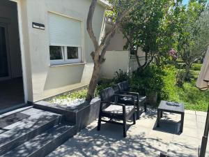 a patio with three chairs and a tree at garden studio in Palit