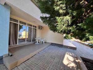 eine Veranda eines Hauses mit einem Tisch und Stühlen in der Unterkunft Sunset Complex Кошарица Апартамент 15 in Kosharitsa