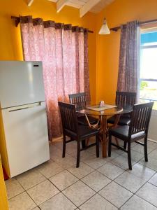 a dining room with a table and a refrigerator at Ellen Bay Cottages in Saint Philips