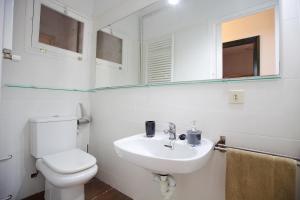 ein Badezimmer mit Toilette, Waschbecken und Spiegel in der Unterkunft Apartamento céntrico en Sant Feliu de Guíxols in Sant Feliu de Guixols