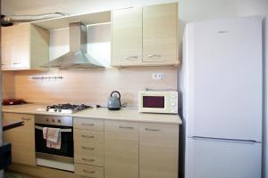 eine Küche mit einem weißen Kühlschrank und einer Mikrowelle in der Unterkunft Apartamento céntrico en Sant Feliu de Guíxols in Sant Feliu de Guixols + 11 Fotos