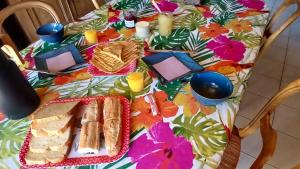a table with a floral table cloth with sandwiches and candles at Ty Eflenn in Locunolé
