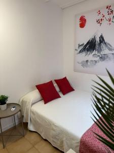 a bedroom with a bed with red pillows on it at Apartamento en el Parque in Ontinyent +19 photos