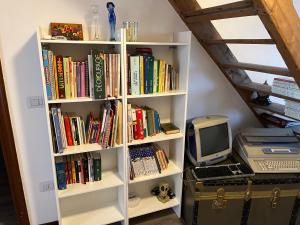 a white book shelf filled with books and a computer at Guest House Al Capitello  +16 photos