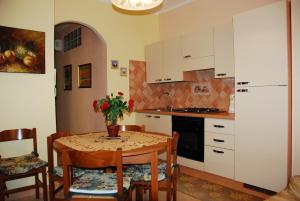 a kitchen with a table and chairs and a kitchen with white cabinets at Villa Lussu in Orosei