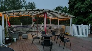 a wooden deck with a gazebo with chairs and a table at Kiinteistö Hetekka in Kouvola