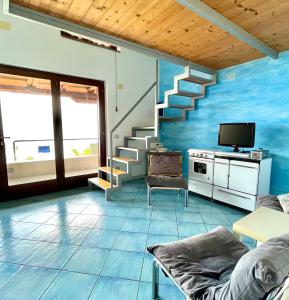 a living room with blue walls and stairs at Casa Trama in Pisciotta