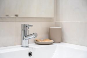 een gootsteen met een kraan en een kom bij GuestReady - Fantastic family home in Salgueiros in Porto