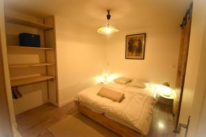 a bedroom with a bed with two lights on it at Le Victoria in Briançon