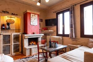 アラコバにあるAgiaz Cozy Apartments Arachovaの暖炉、テーブル、ベッドが備わる客室です。