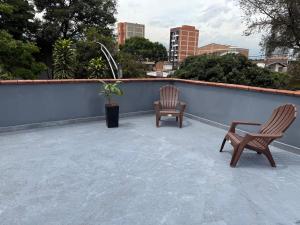 two chairs and a table on a roof at Hotel De León Estadio in Medellín