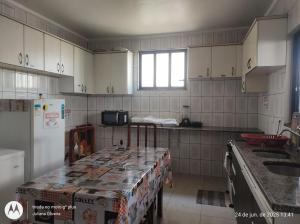 a kitchen with white cabinets and a table in it at Duque HOSTEL in Belém