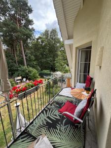 a balcony with a table and chairs on a porch at Waldhaus Frohsinn in Heringsdorf