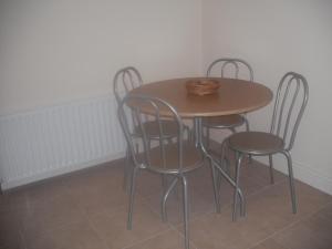 a table and four chairs in a room at The Blue House Apartments in Bushmills