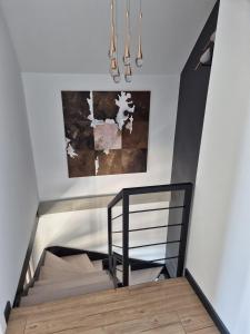 a staircase in a room with a painting and a chandelier at Widokownia Bukowinki 2 in Chmielno +19 photos