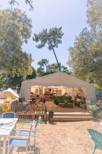 a gazebo with chairs and tables and chairs at Le Spot Saint-Trojan in Saint-Trojan-les-Bains