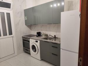 a kitchen with a sink and a washing machine at Simply House in Faro