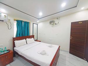 ゴカルナにあるFLORA INN Gokarnaのベッドルーム1室(ベッド1台、帽子2つ付)