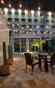 a patio with a table and chairs and a building at Zurban Travelers in Paraíso