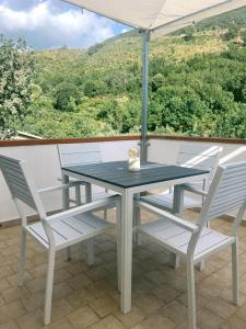 a table and chairs on a balcony with an umbrella at Colibrì in Maierà