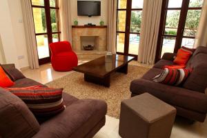 un salon avec deux canapés et une cheminée dans l'établissement Aphrodite Hills Superior Villas Superior Villa 0066 Air Conditioning, à Paphos