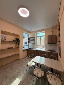 a kitchen with a table and chairs in a room at Happy Home Hostel in Odesa