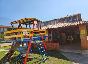 a playground with a ladder next to a building at Chalé Maresia Maranduba in Ubatuba