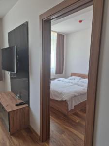 a mirror in a bedroom with a bed and a table at President kop apartment 412 in Kopaonik