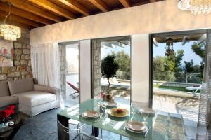 a living room with a glass table and a couch at Executive Rhodes Villa Villa Ellie 2 Bedroom Villa With Sea Views Pefkos in Pefki Rhodes