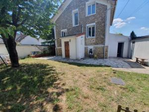 a house with a tree in front of it at Belle maison meulière 135m2 in Livry-Gargan
