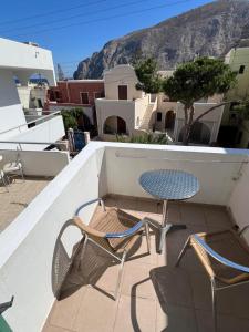 a patio with two chairs and a table on a balcony at Santa Magia in Kamari
