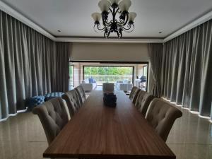 a conference room with a long wooden table and chairs at Jumanji Safaris Villa Constantia in Cape Town +32 photos