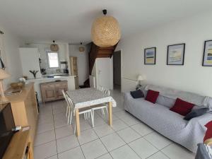 un soggiorno con un divano e un tavolo di Charmant pavillon 3 chambres près de la plage, jardin, wifi, accepte petits animaux, non-fumeur - FR-1-236-140 a Cucq Altre 13 foto