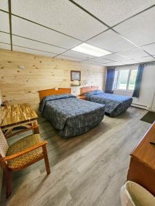 due letti in una stanza con pareti in legno di Katahdin Valley Motel  Altre 47 foto