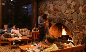 a group of people in a living room with a fireplace at Glacier Bay Lodge in Gustavus