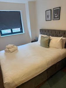 una camera da letto con un grande letto bianco con una finestra di Stylish 2 Bed Flat by O2 Arena Modern Comfort in Central Birmingham a Birmingham