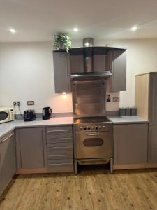 una cucina con piano cottura in acciaio inossidabile forno superiore di Stylish 2 Bed Flat by O2 Arena Modern Comfort in Central Birmingham a Birmingham