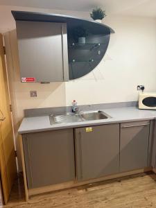 un bancone della cucina con lavandino e specchio di Stylish 2 Bed Flat by O2 Arena Modern Comfort in Central Birmingham a Birmingham Altre 25 foto