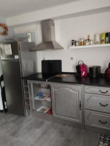 a kitchen with a stainless steel refrigerator in a room at T1 bis indépendant dans maison individuelle in Albi