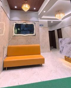 ナーグプルにあるHotel Aasi innの壁のある部屋のオレンジ色のソファ