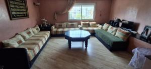 a living room with two couches and a table at Residence Imane in Mohammedia