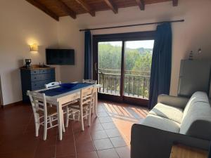a living room with a table and chairs and a balcony at Appartamento La Vela Blu in Cuile Pazzoni +10 photos