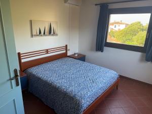 a bedroom with a bed and a window at Appartamento La Vela Blu in Cuile Pazzoni