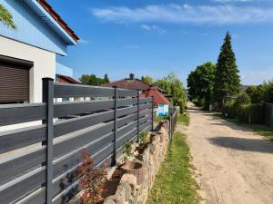 een hek naast een huis en een onverharde weg bij Ferienhaus auf Usedom, Neeberg in Krummin