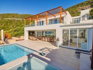 a villa with a swimming pool and a house at Secret Sands in Wilderness