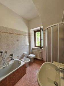 a bathroom with a tub and a toilet and a sink at Cà del Pero - Tre Ville in Preore