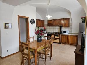 a kitchen with a wooden table and chairs and a kitchen with a refrigerator at Cà del Pero - Tre Ville in Preore